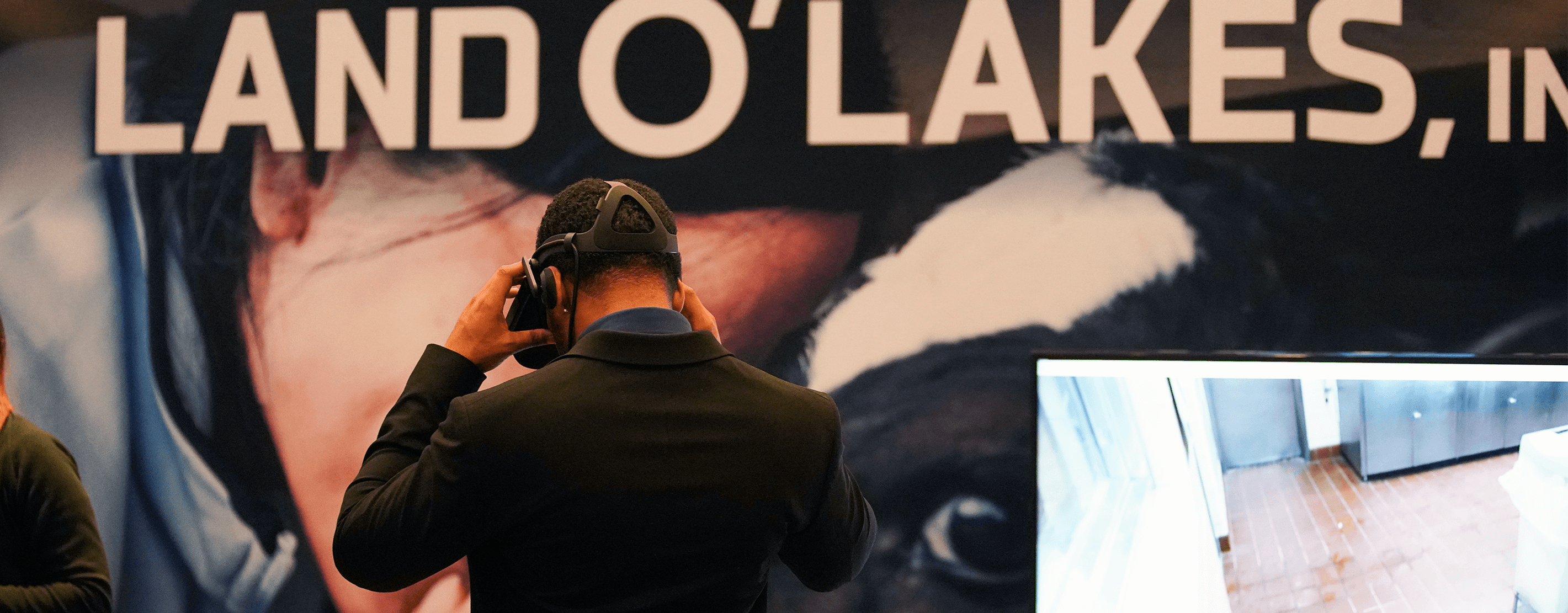 A Man Wearing Virtual Reality Goggles At A Land O'Lakes, Inc. Exhibit