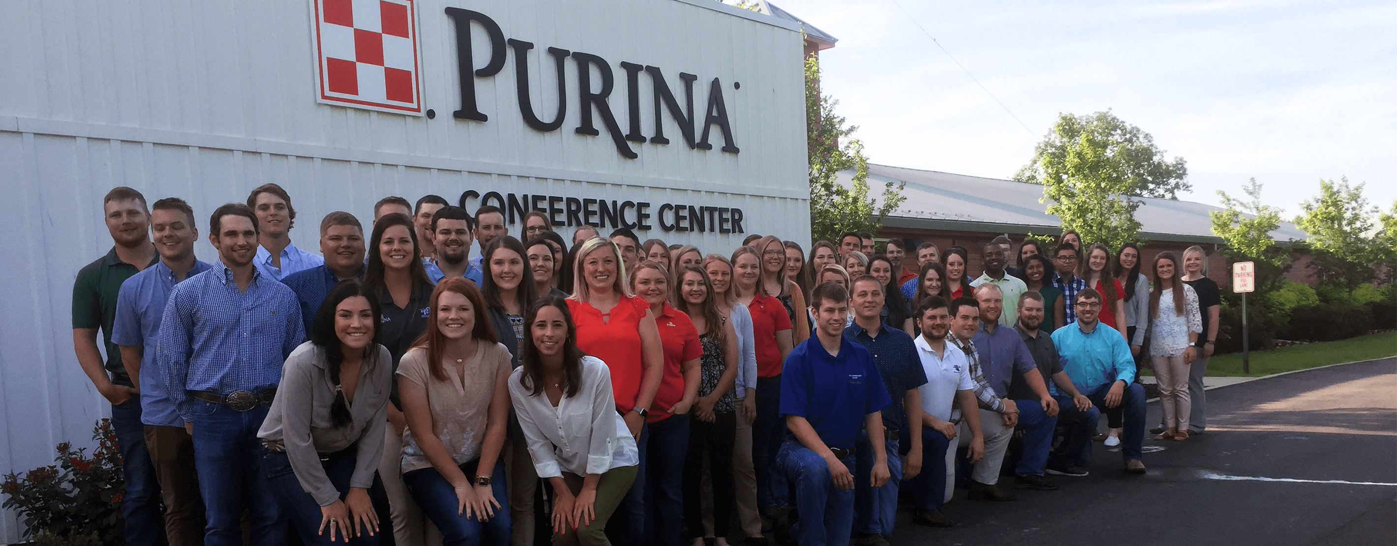 Purina Interns Posing For A Photo In Front Of A Feed Facility
