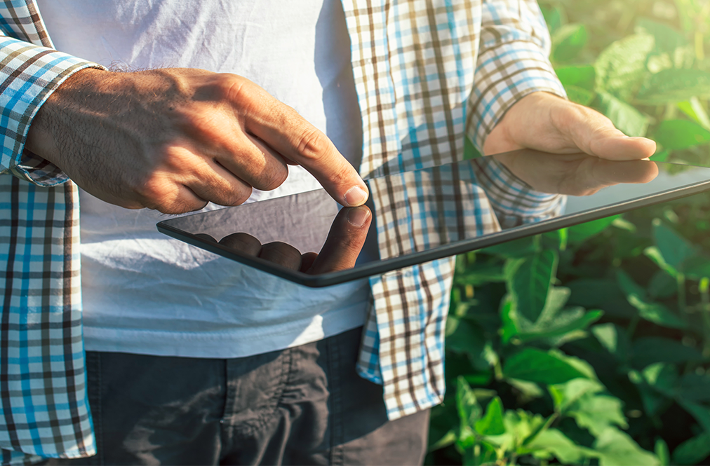 photo of man in field holding an ipad 