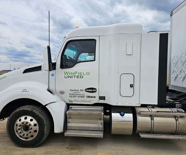 The cab of a semi truck. It's white and has "WinField United" on the door.