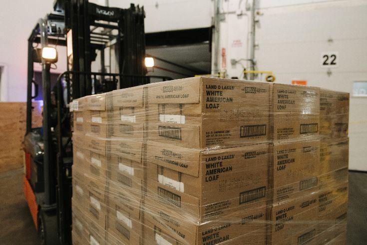 A forklift moves a pallet of boxes of Land O Lakes White American Loaf.
