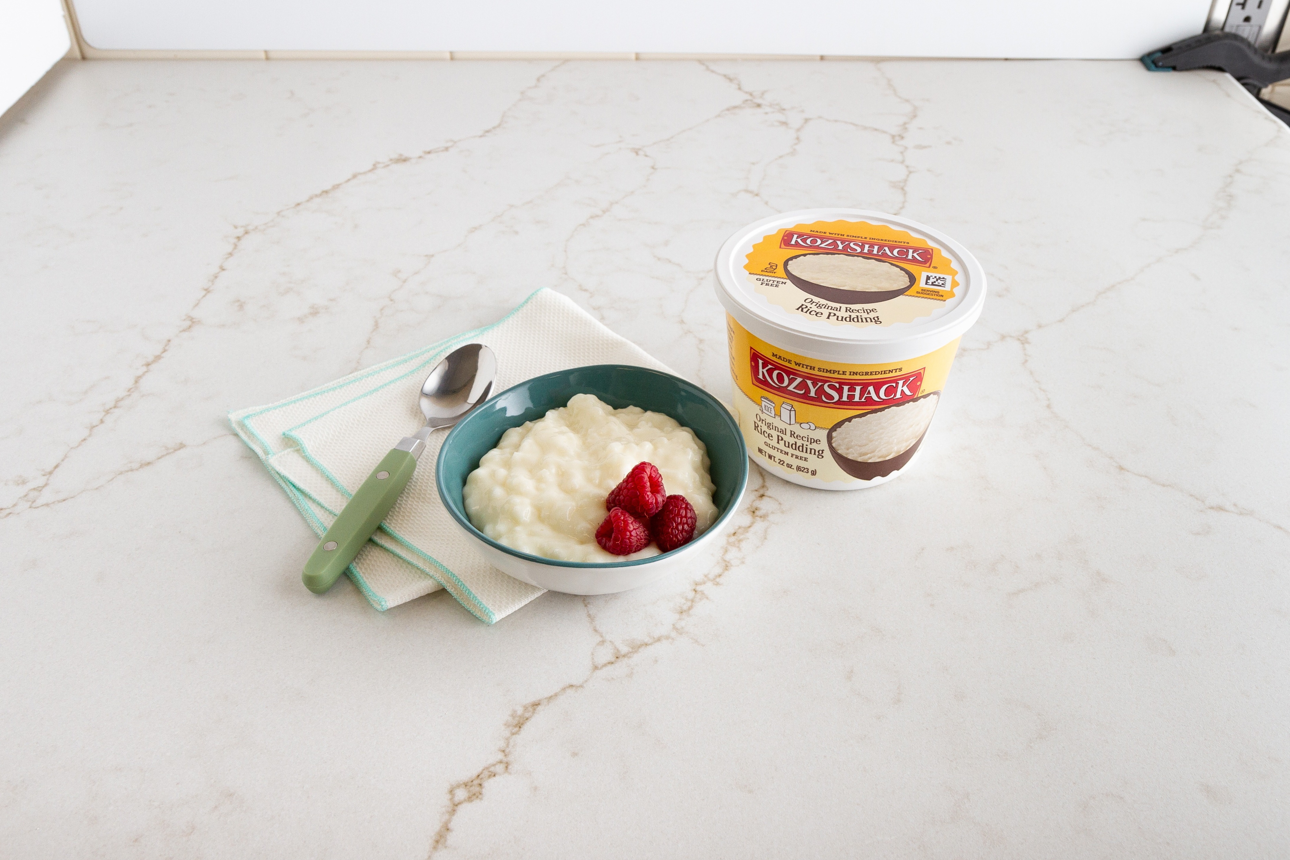 A dish of Kozy Shack rice pudding topped with raspberries.