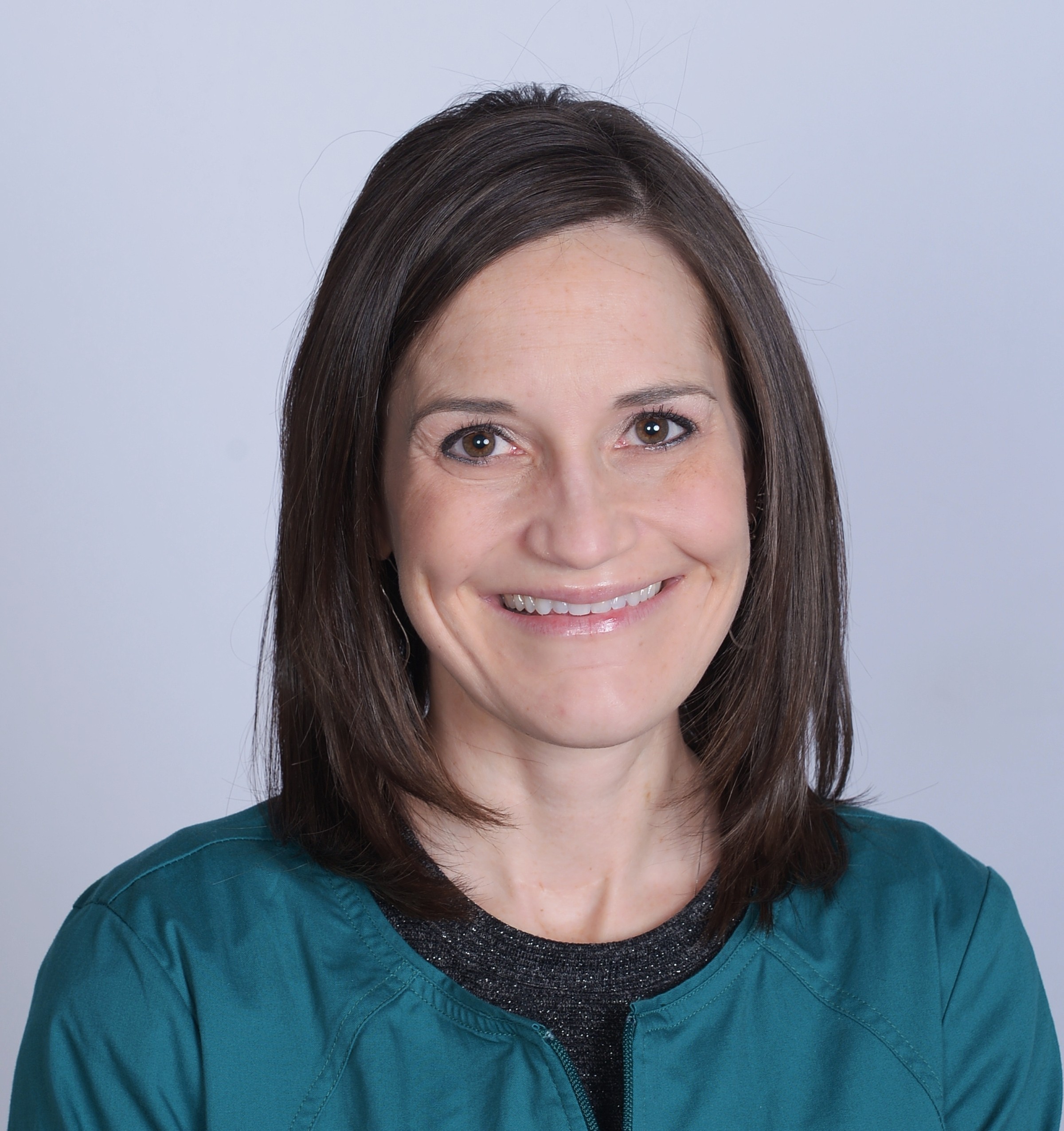 Headshot of a person smiling against a plain background.