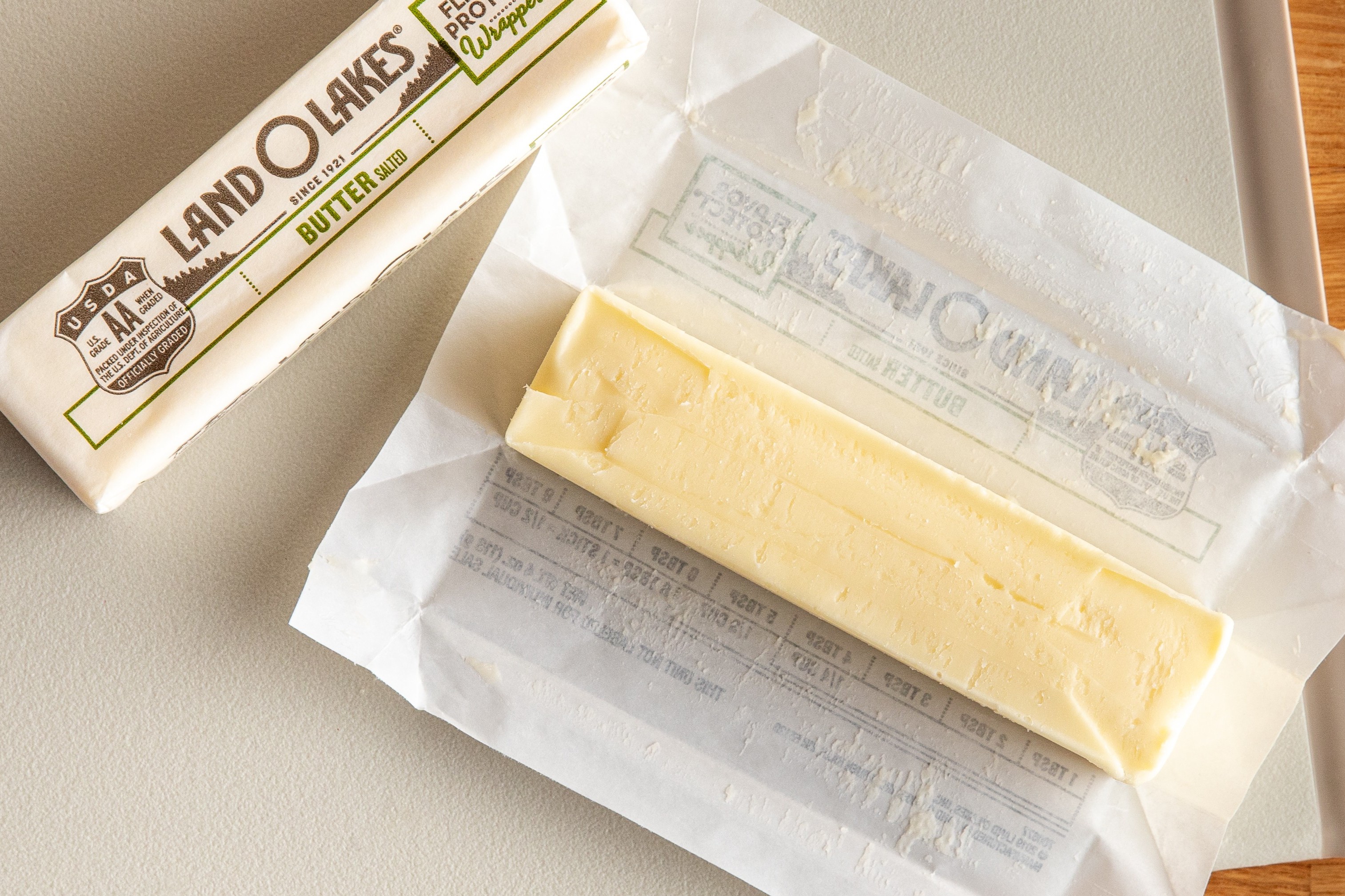 Land O'Lakes butter stick partially unwrapped on a countertop.