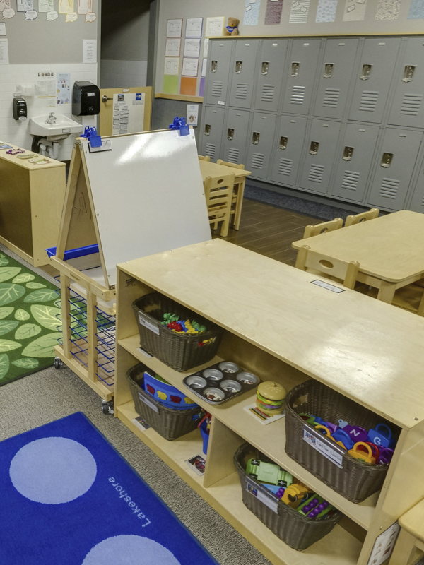 A classroom with lockers, a whiteboard and shelves