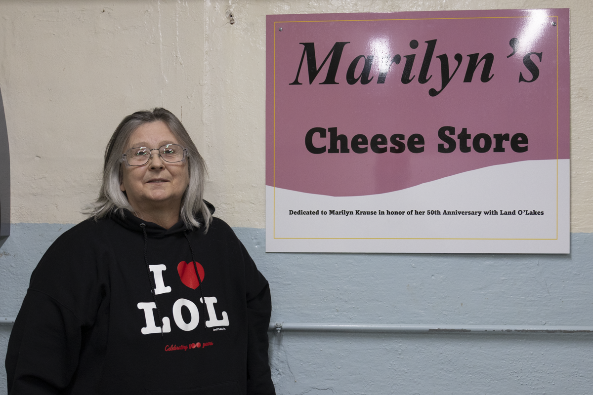 A woman stands in front of a sign