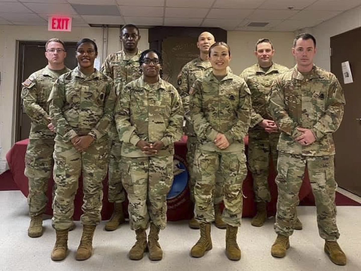 A group of soldiers pose in a room.